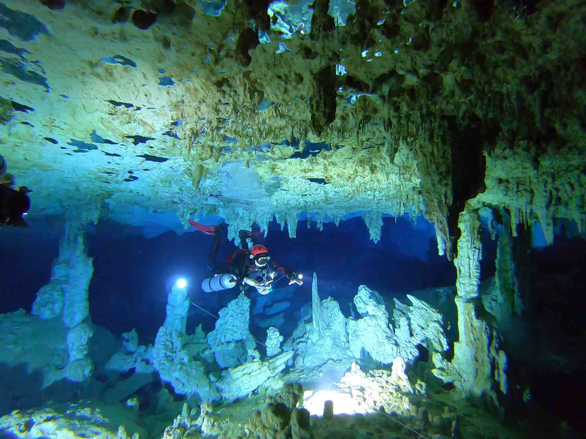 cave diver illuminating cave formations