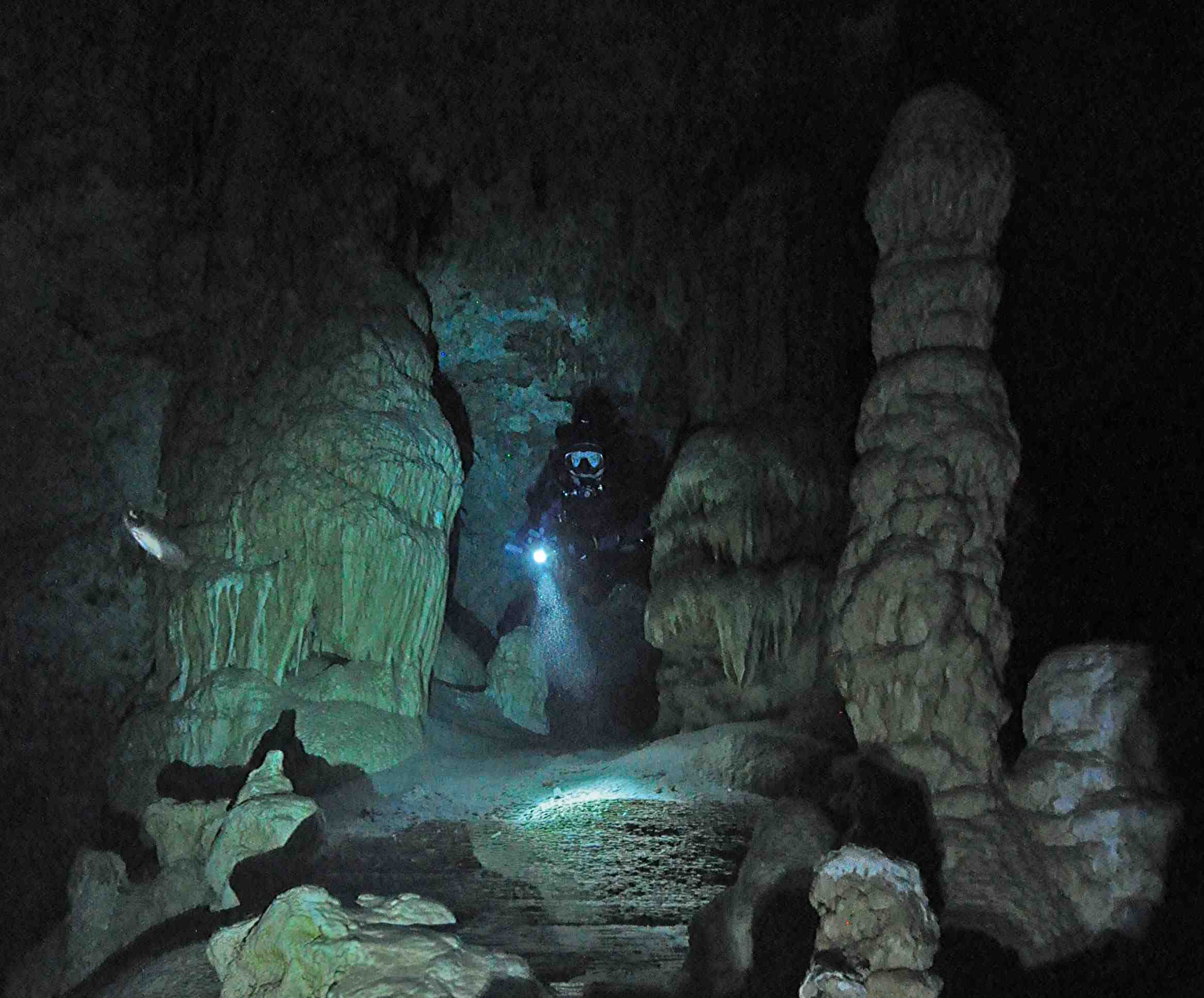 cave diver surrounded by majestic cave formations