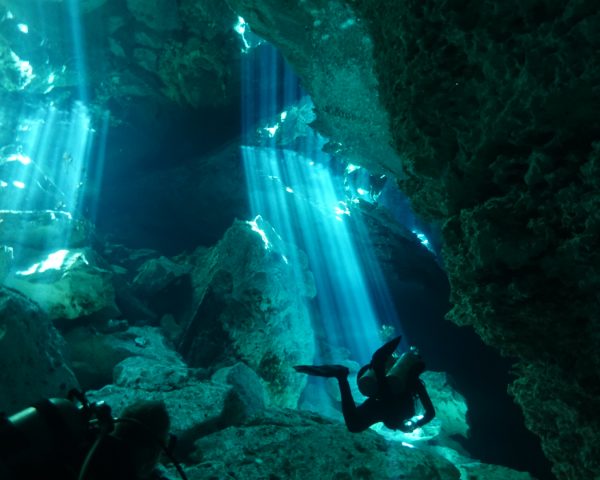 Divers passing amazing light beams.