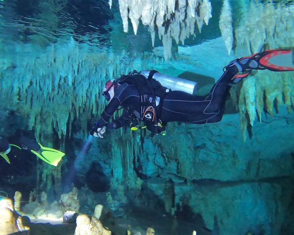 Diver floating through the waters in Cenote Taak Bi Ha