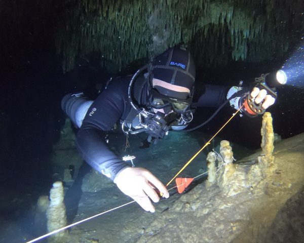 cave diver connecting his line to permanent cave line during cave diver training.