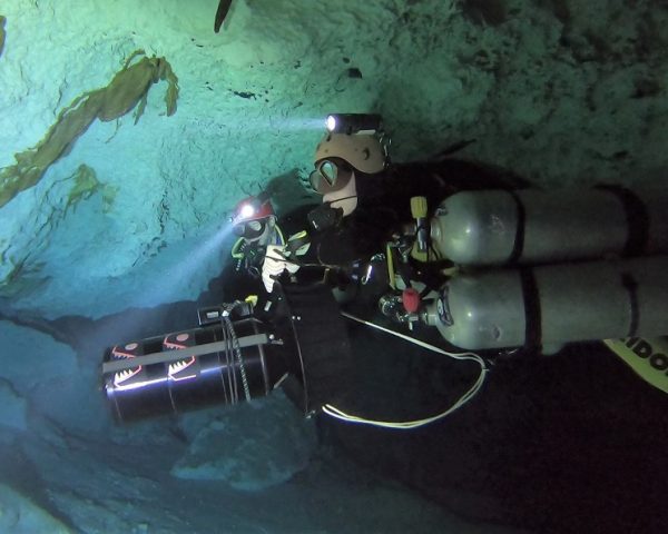 Cave divers with diver propulsion vehicle (DPV).